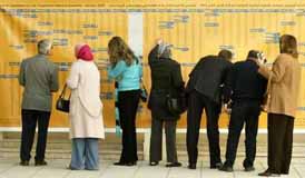 Iraqis look at list of the candidates for the transitional national assembly in a polling station in Amman. (Foto: REUTERS/Ali Jarekji)